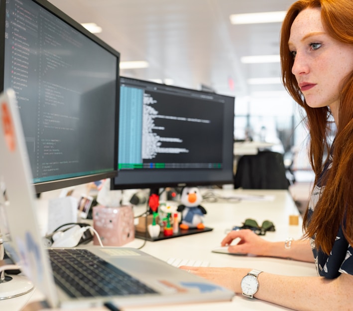 woman in green shirt sitting in front of computer