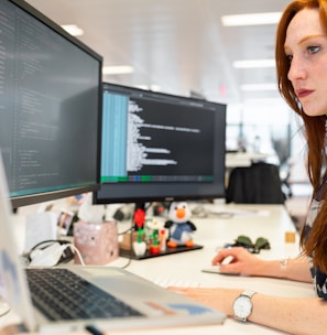 woman in green shirt sitting in front of computer