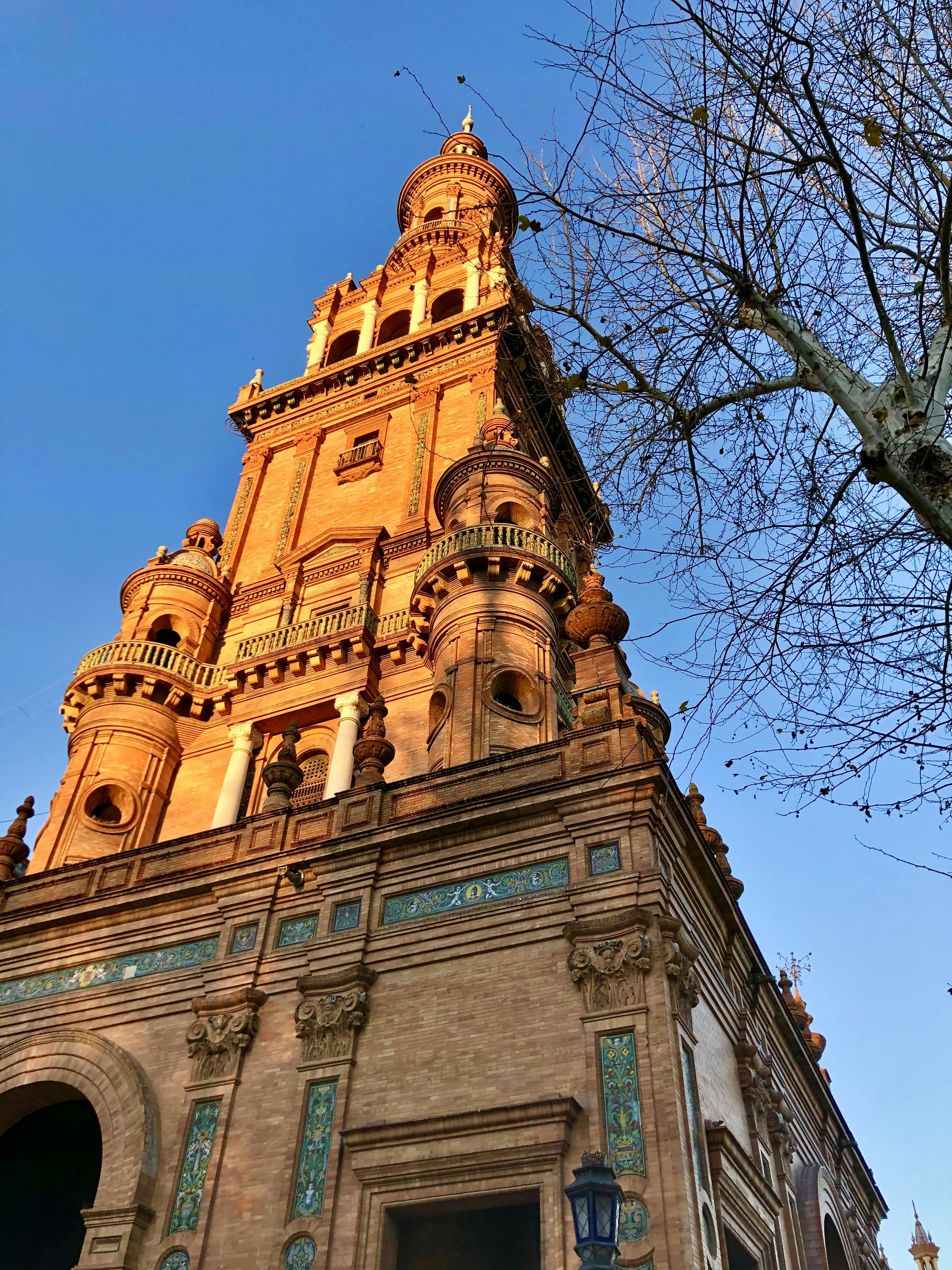 One of the towers at Plaza de Espana in Seville, Spain during sunset. An ideal starting point for travelers to explore the many beautiful sights in this ancient city.