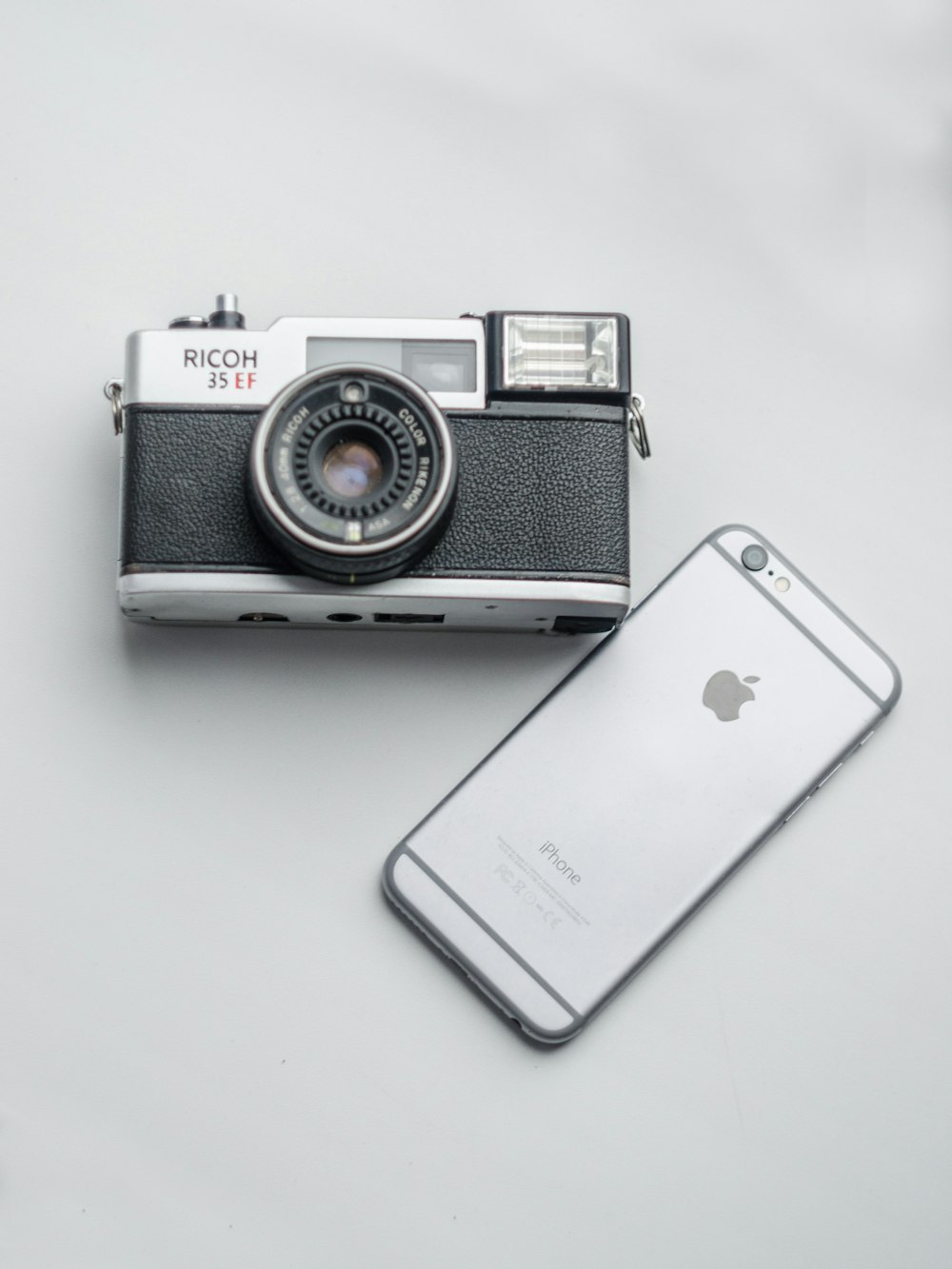 silver iphone 6 beside silver and black camera