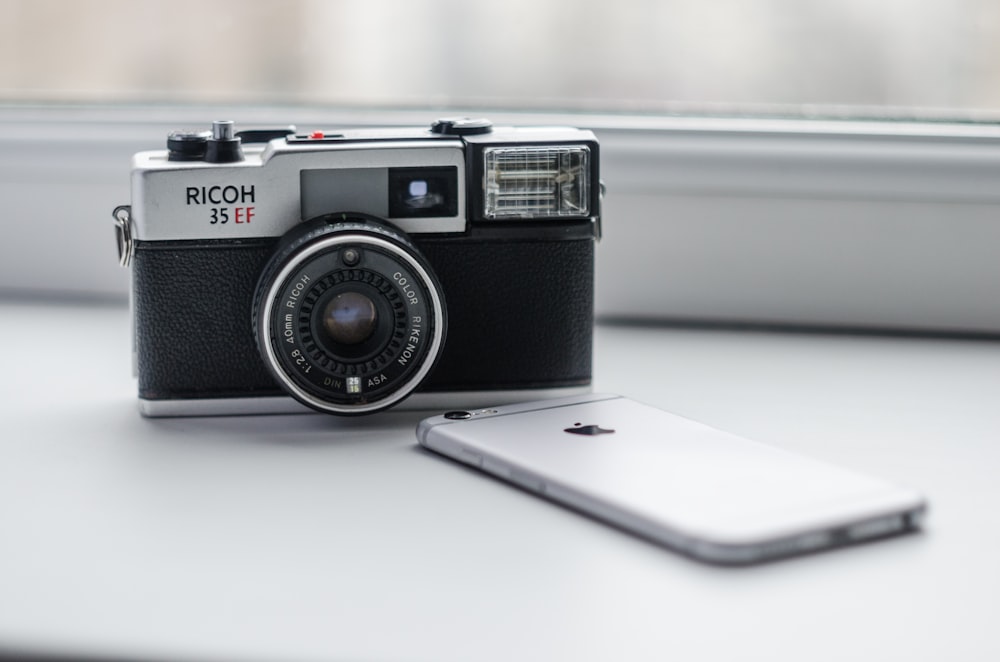 black and silver camera on white table