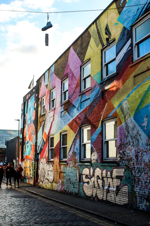 Urban shoes showcased against a backdrop of colorful city murals at sunset.