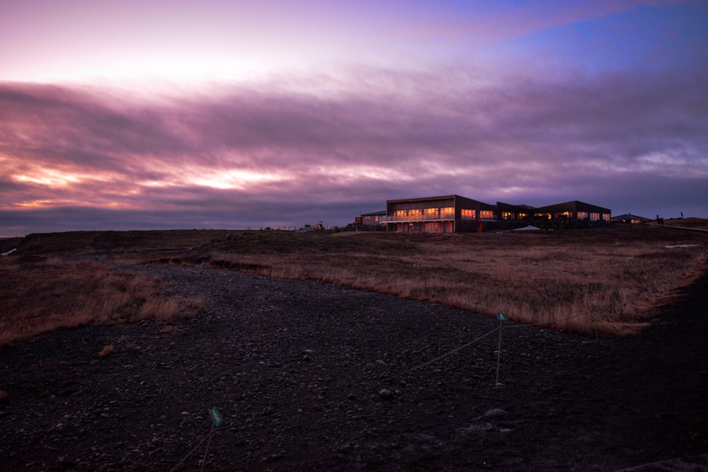 brown wooden house on brown field under gray clouds