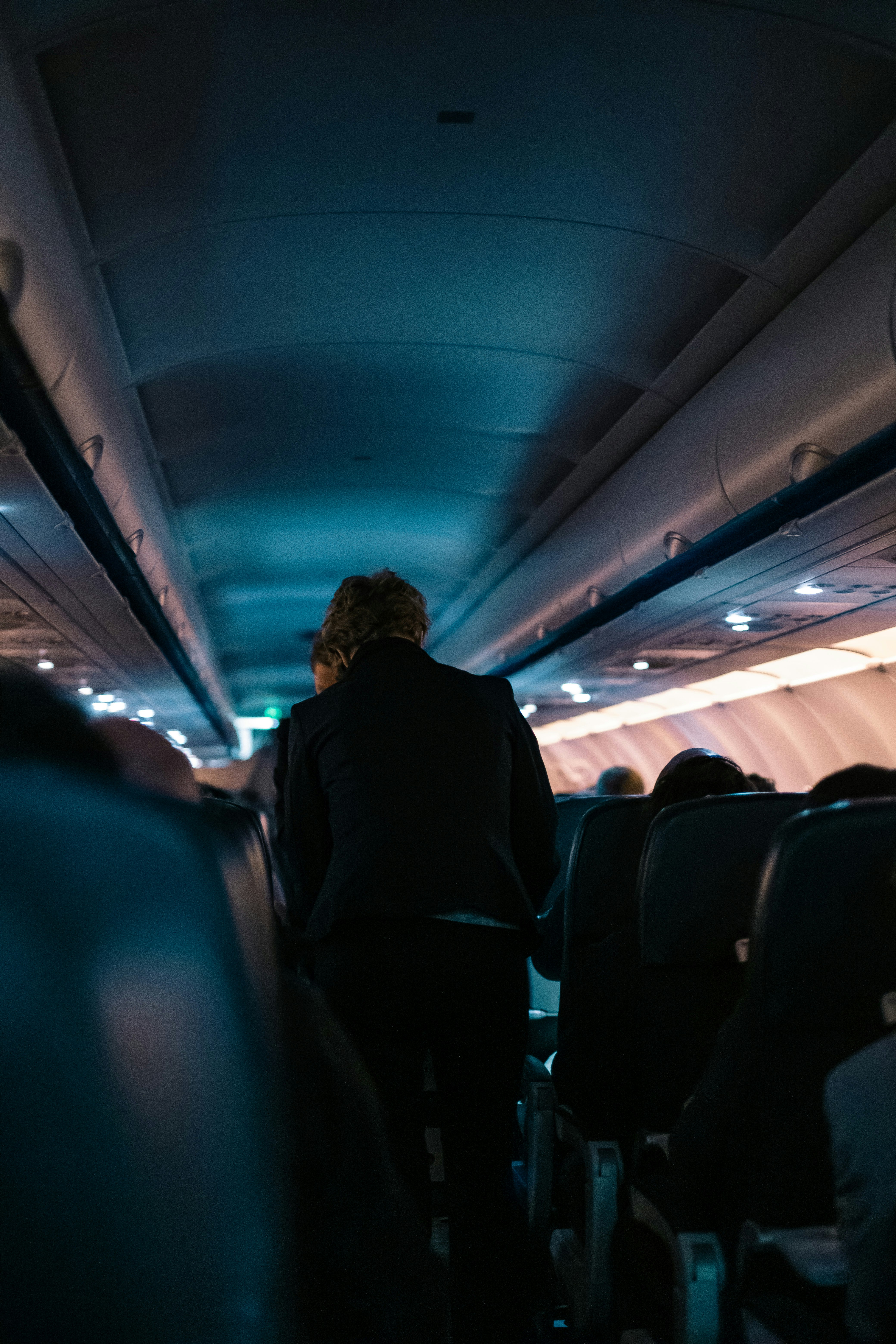 man in black jacket sitting on blue seat