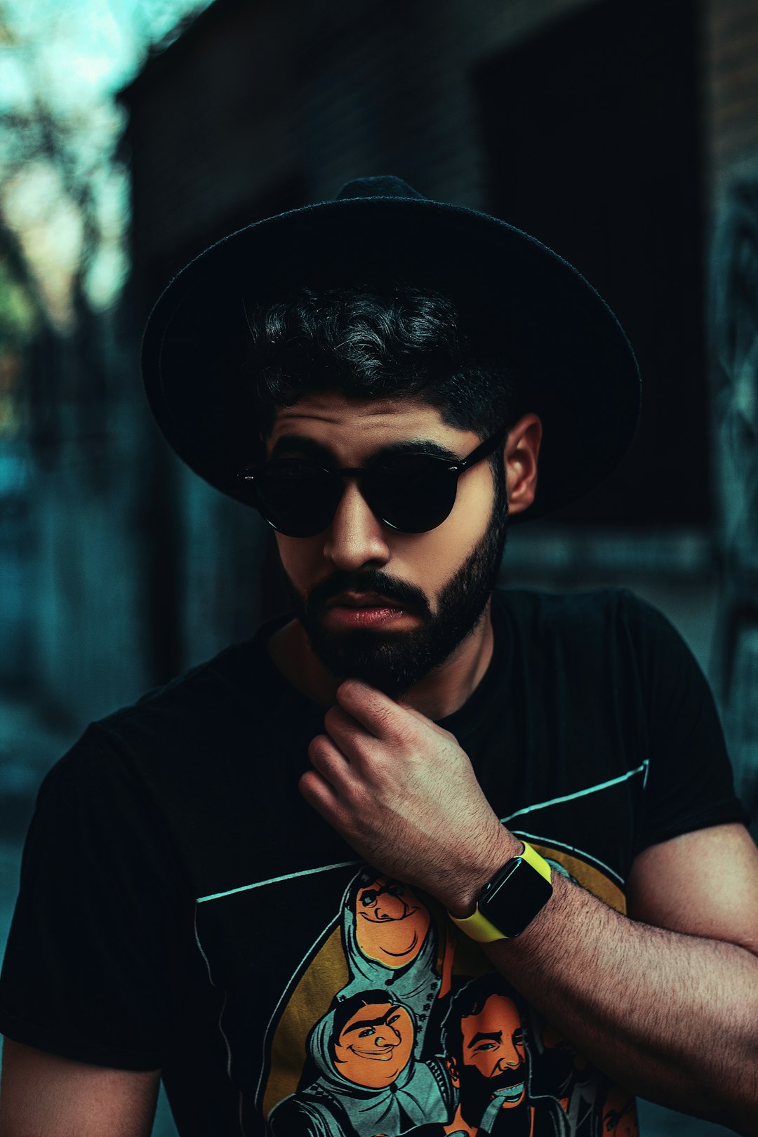 man in black crew neck shirt wearing black sunglasses and black hat