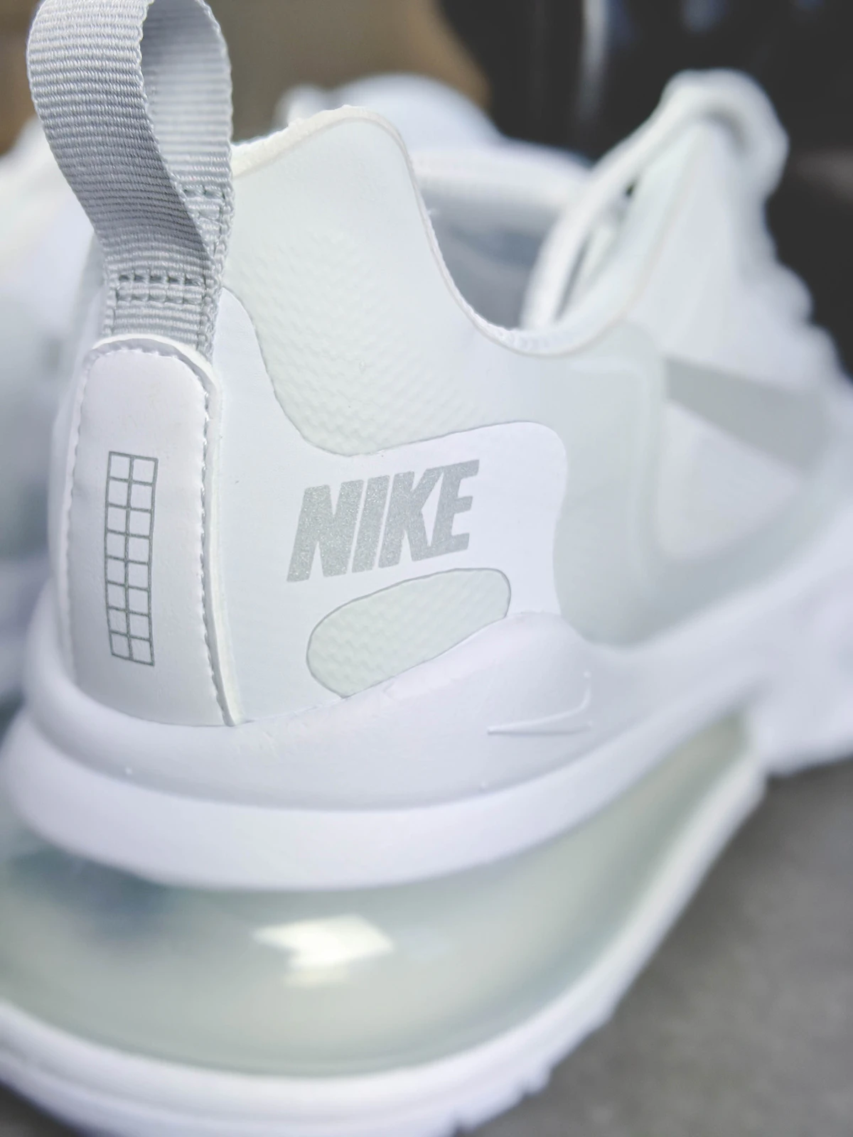 White Nike Air Max running shoes with large air bubble sole on clean background