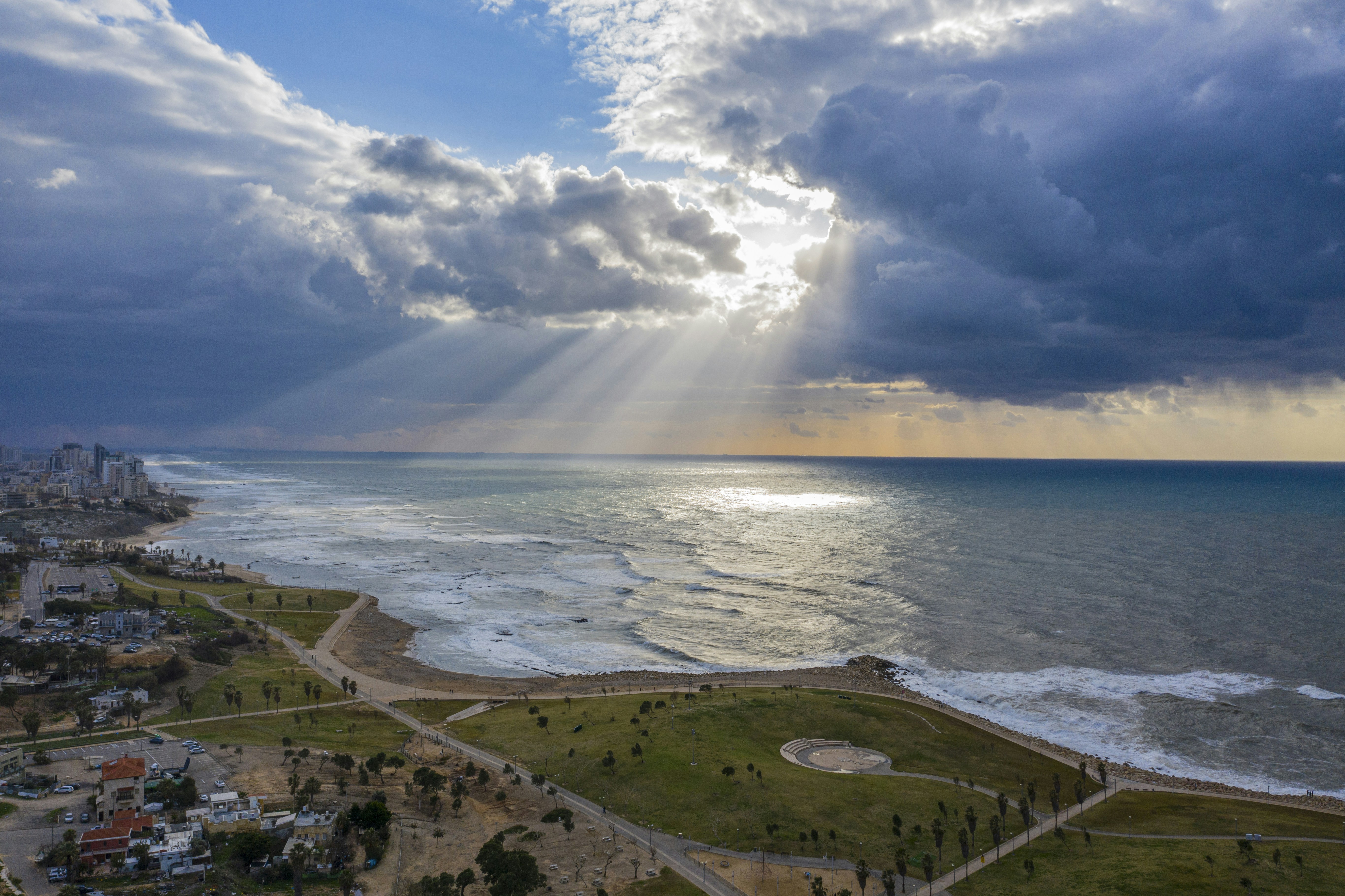 aerial view of city near sea during daytime, Sunset on a rainy day in the Tel Aviv coastline, Israel.