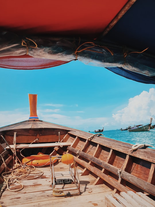 brown wooden boat on sea shore during daytime in Ao Nang Thailand
