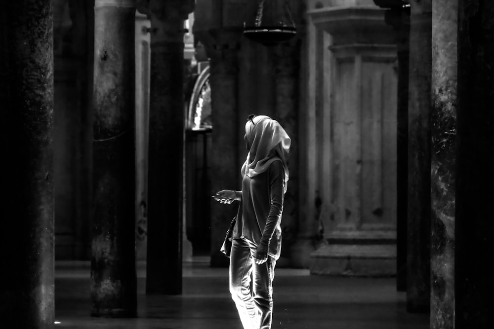 grayscale photo of woman in white dress walking on sidewalk