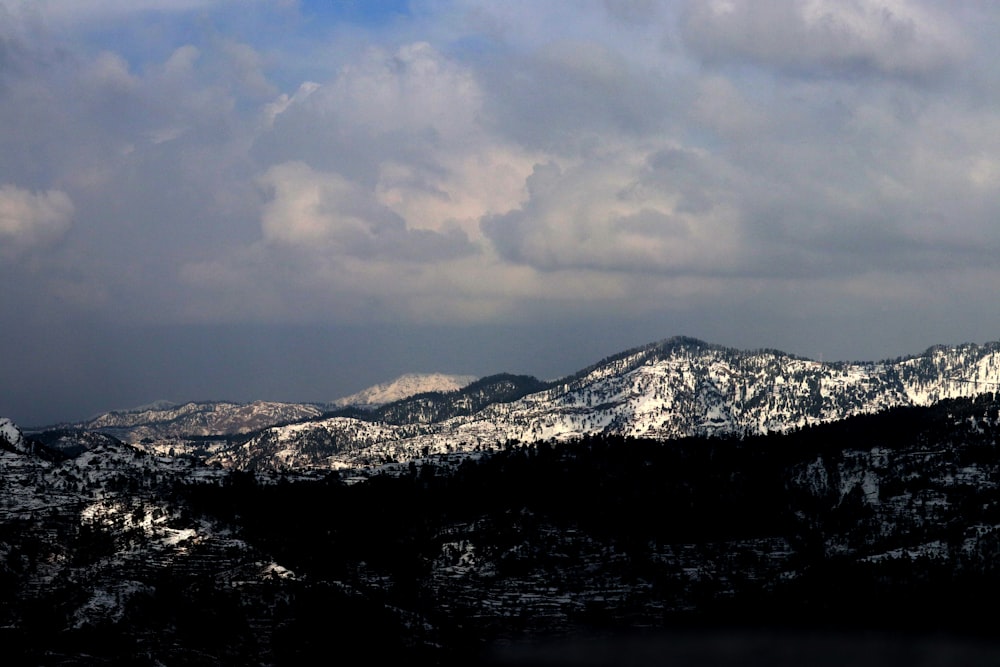 snow covered mountain under cloudy sky during daytime