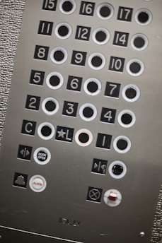 Close-up of a modern elevator control panel with digital displays and sleek buttons.