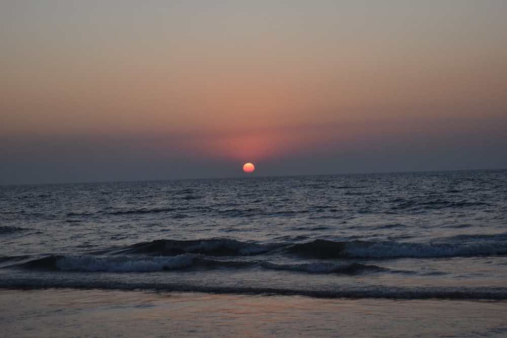 Les vagues de l’océan s’écrasent sur le rivage au coucher du soleil