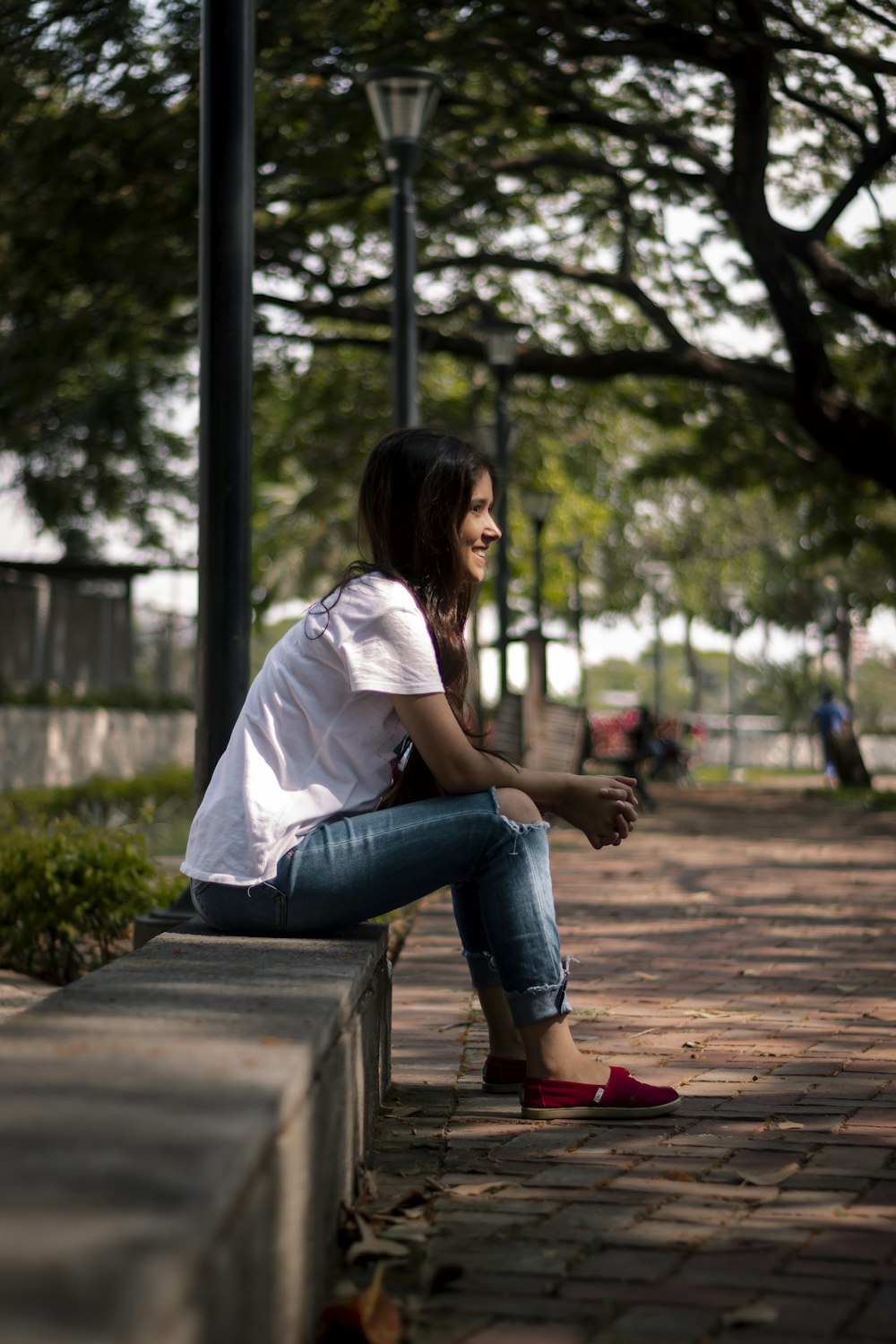 a woman sitting on a bench in a park