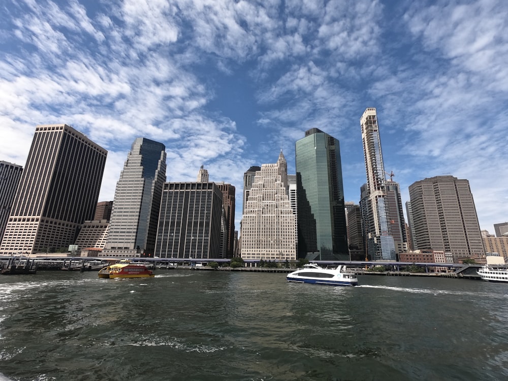 white boat on water near city buildings during daytime