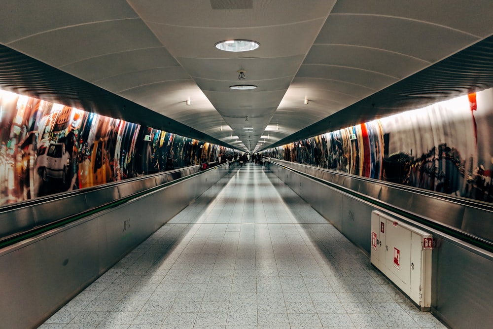 people walking on hallway with lights turned on during nighttime