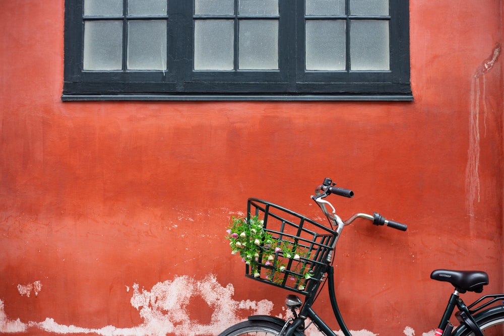 black city bike beside red wall