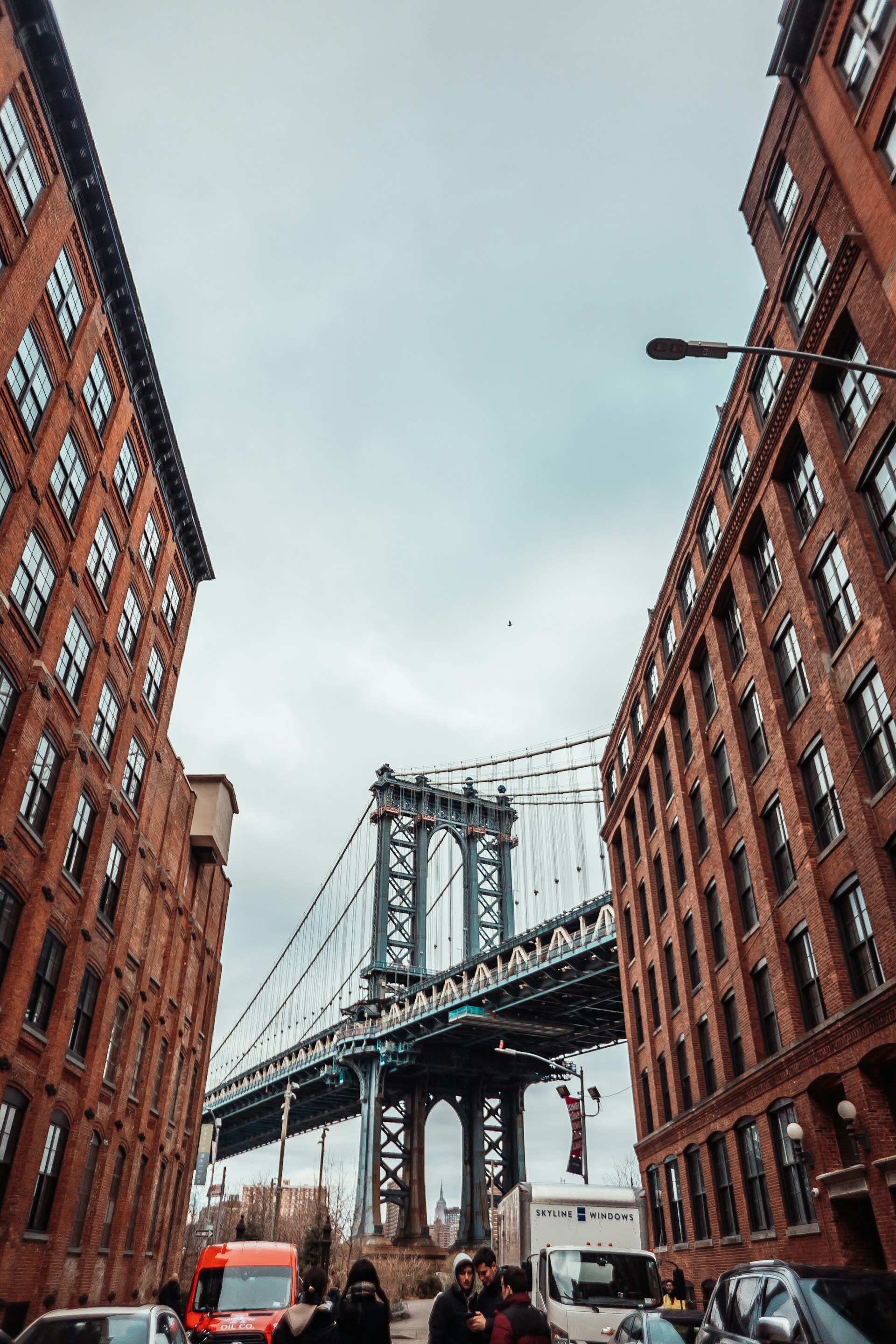 brown concrete building near bridge under white clouds during daytime