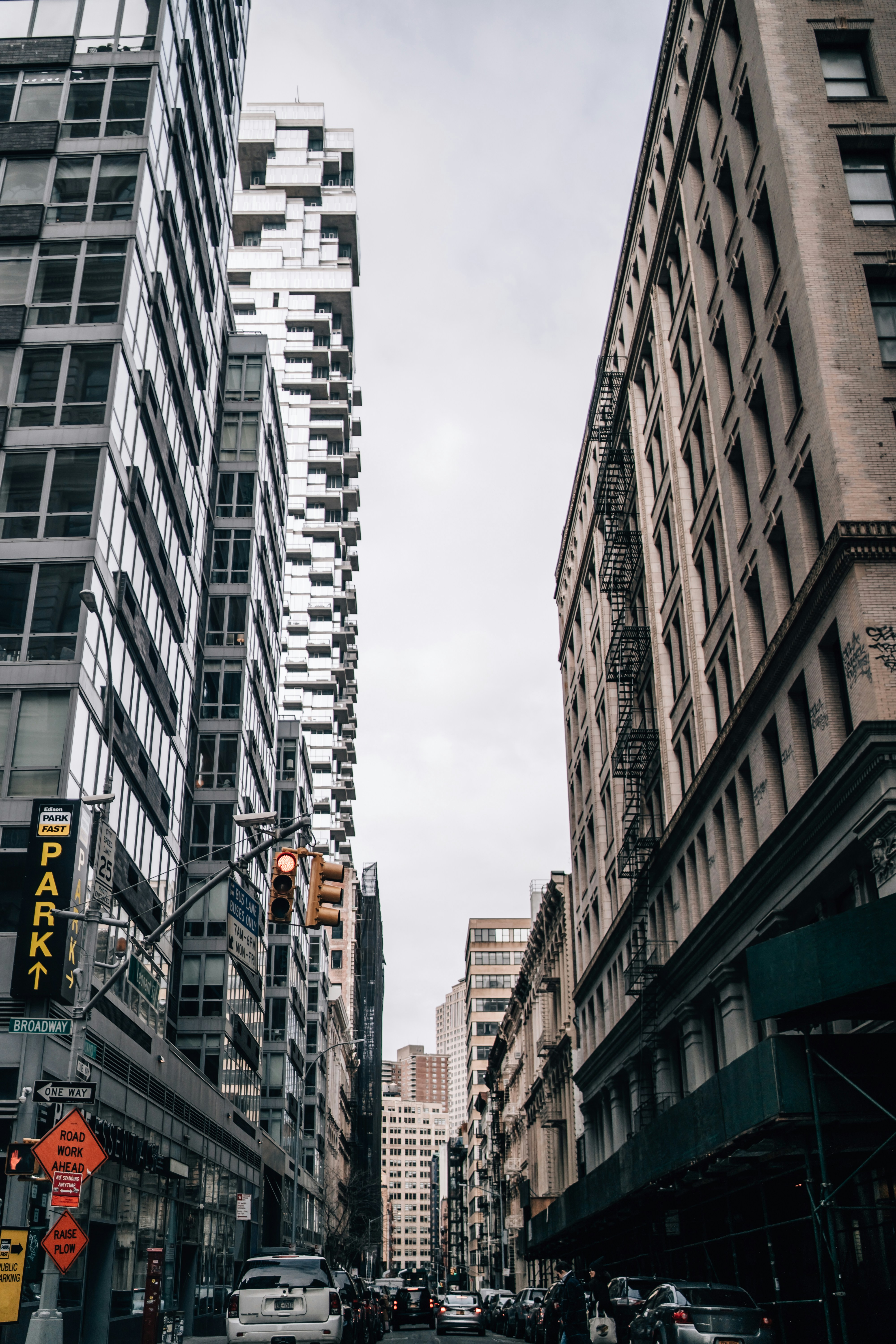 cars on road between high rise buildings during daytime