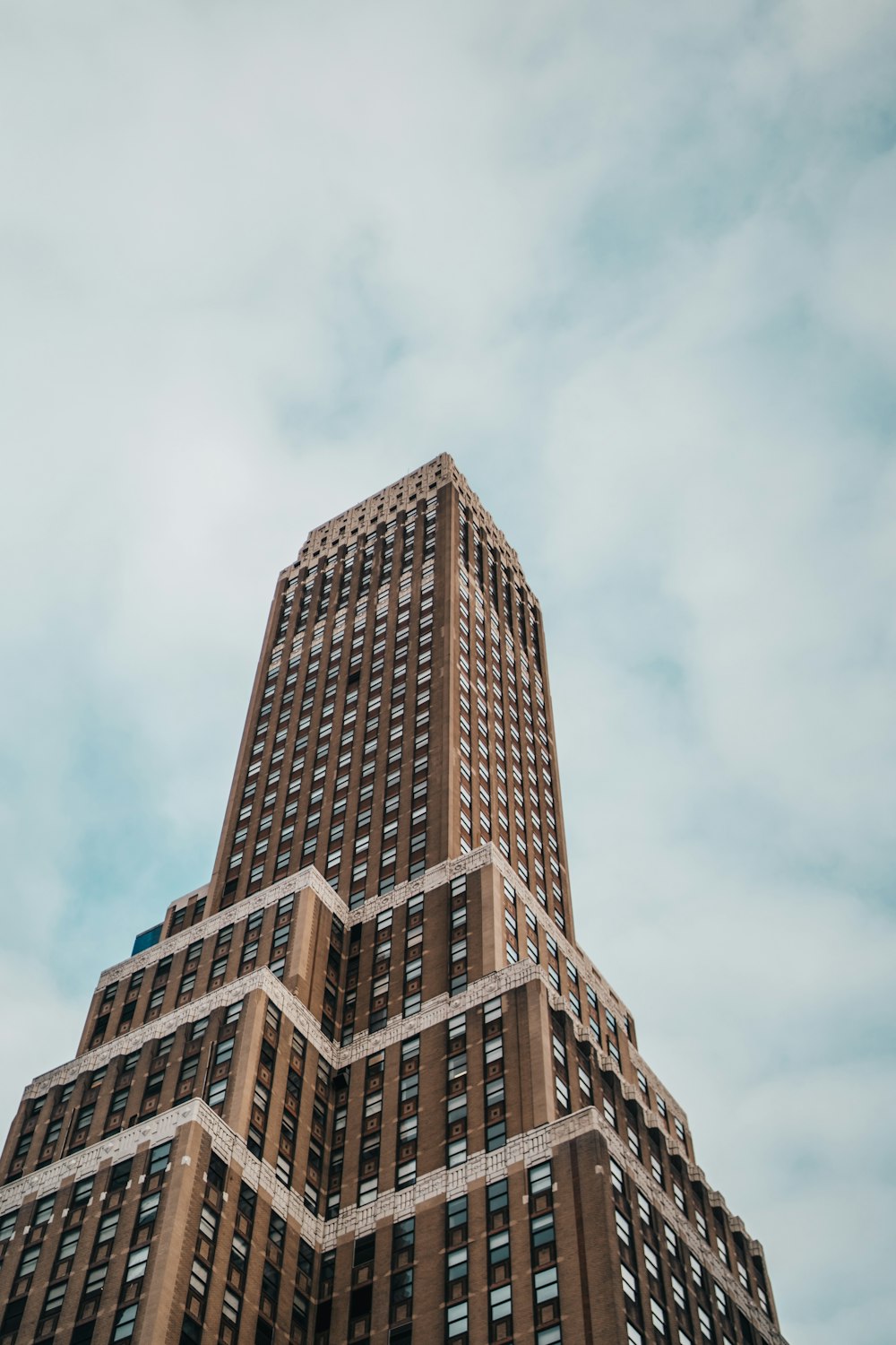 brown concrete building under white clouds during daytime