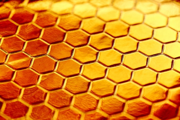 A modern hexagonal pattern background with subtle honeycomb shapes in warm yellow tones.