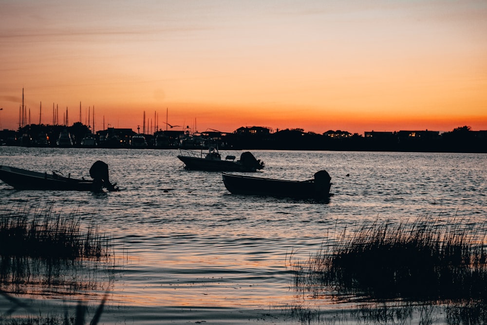 silhouette of people riding on boat during sunset