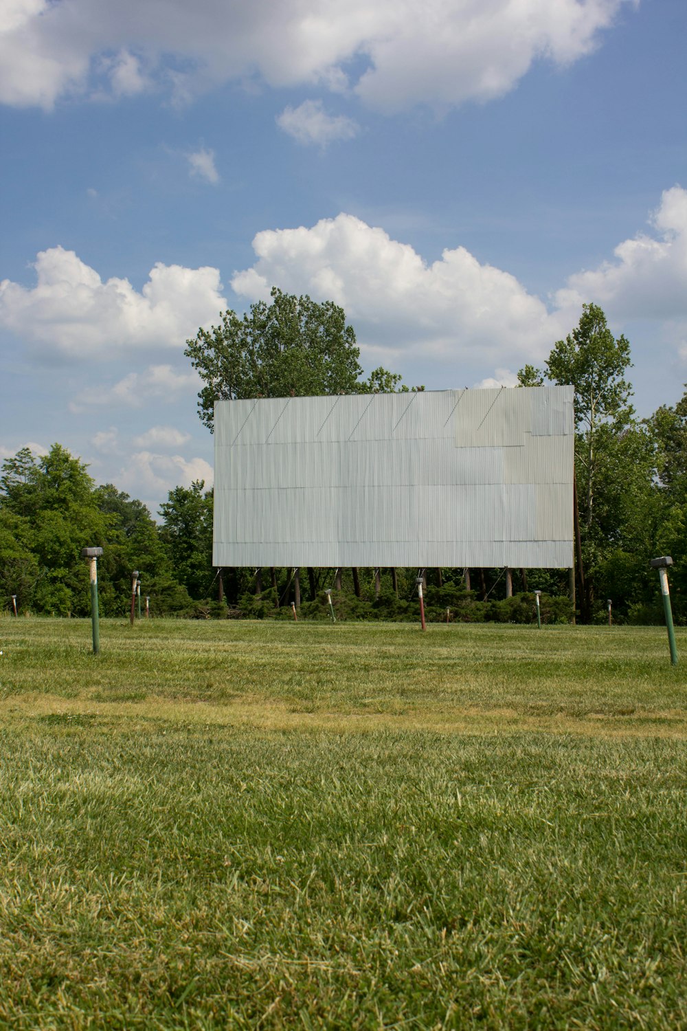 white and black building on green grass field under white clouds during daytime