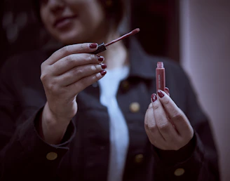 person holding red pen and writing on paper