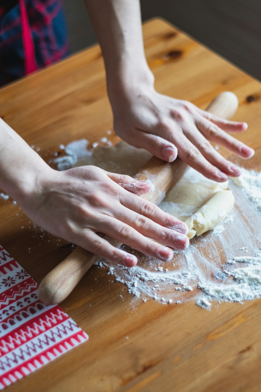person holding dough on brown wooden table