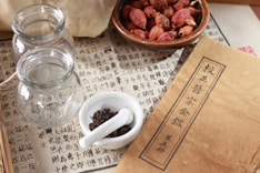 white ceramic mug on white ceramic saucer beside clear glass jar