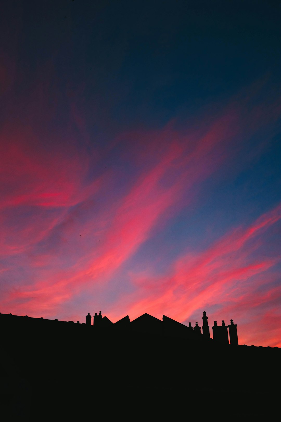 silhouette of city buildings under red sky