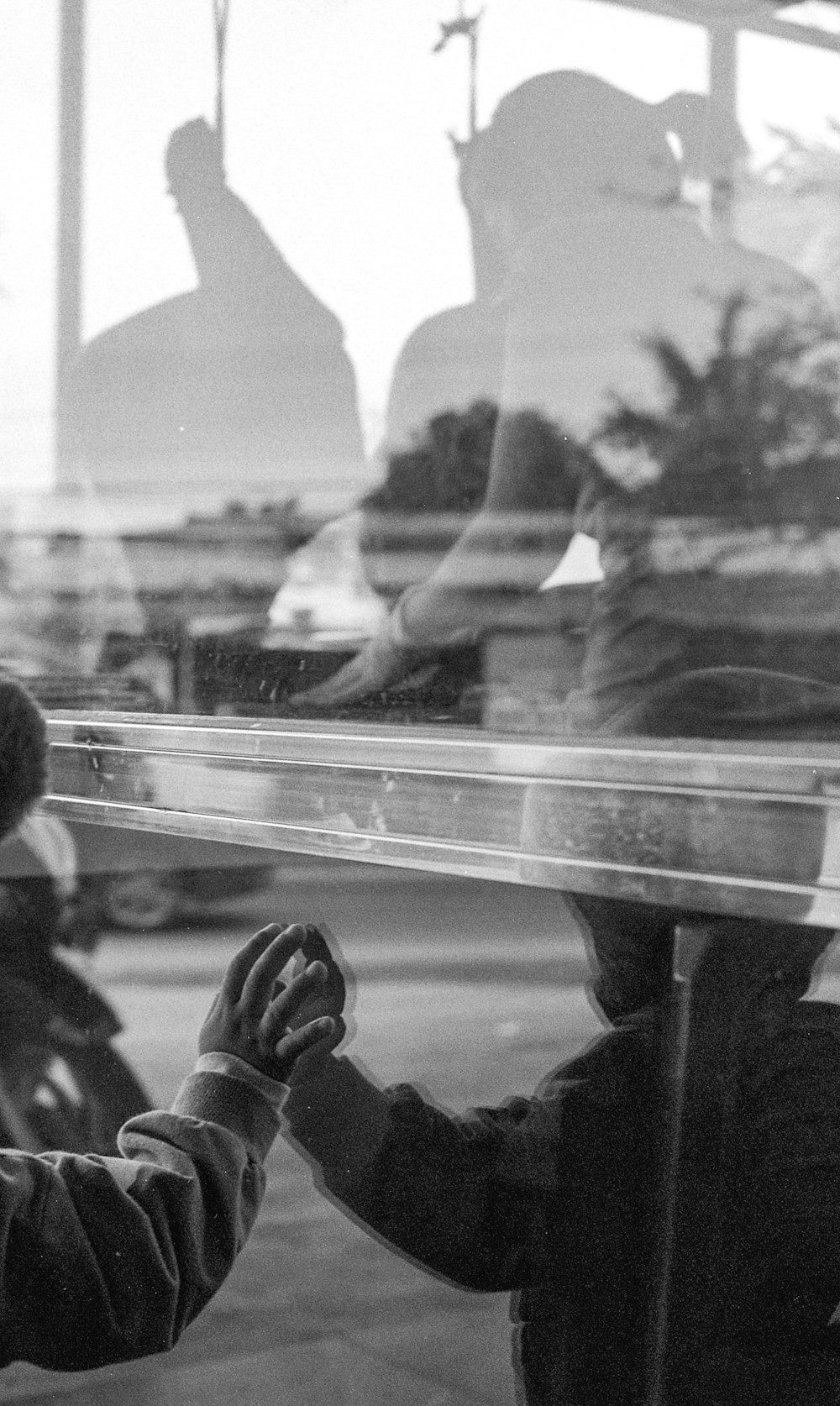 grayscale photo of people sitting on bench