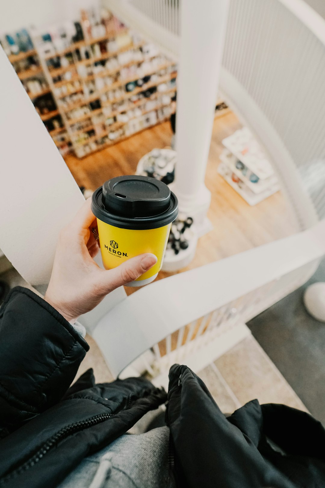 person holding yellow and black coffee cup
