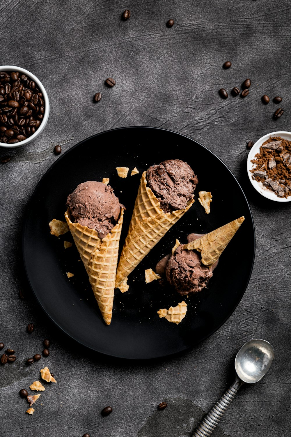 검은 둥근 접시에 초콜릿 아이스크림을 곁들인 와플