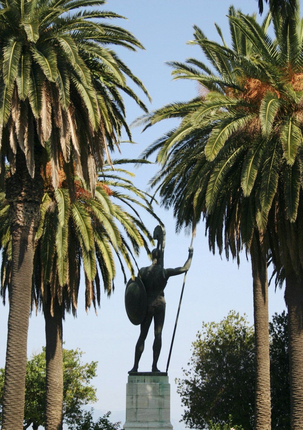 estátua preta do elefante na palmeira verde durante o dia