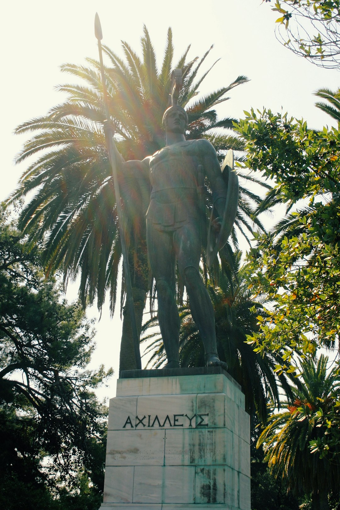 statue of man near green trees during daytime