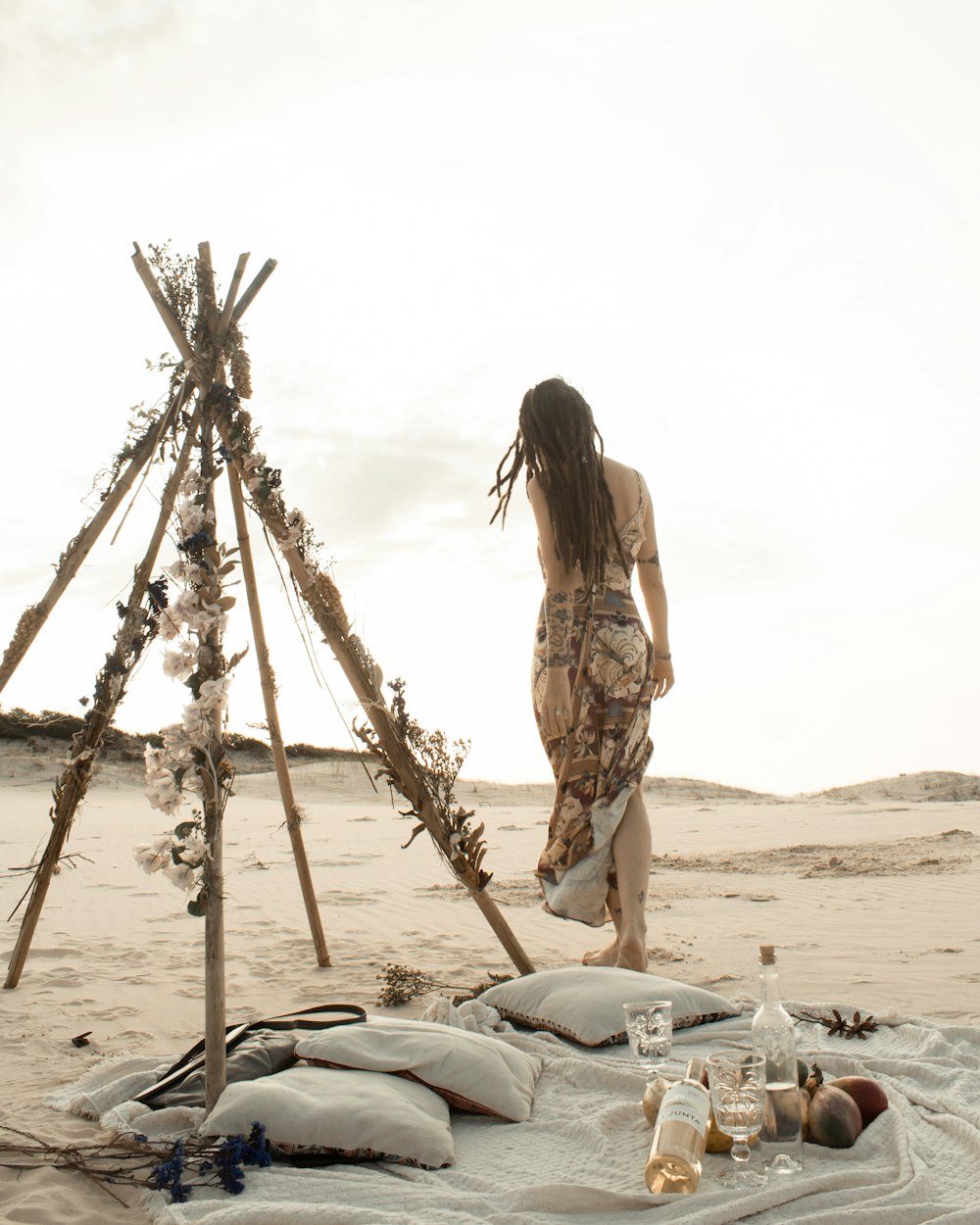 woman in brown and white floral dress standing on beach during daytime