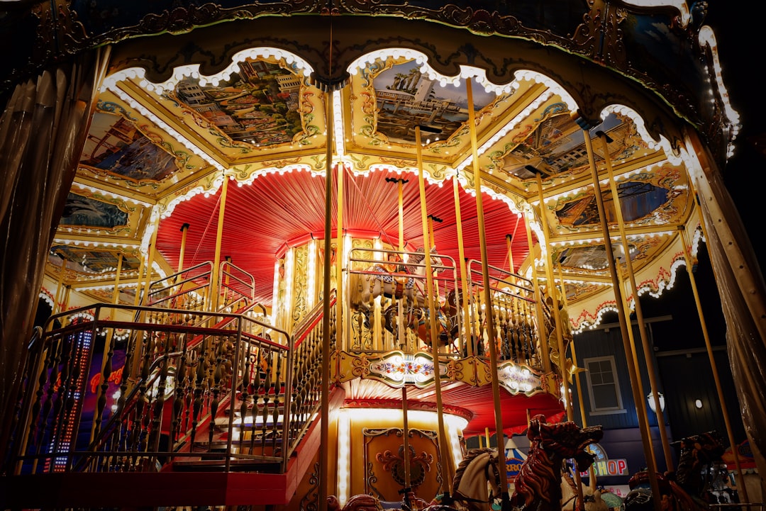 people sitting on red chairs in front of carousel