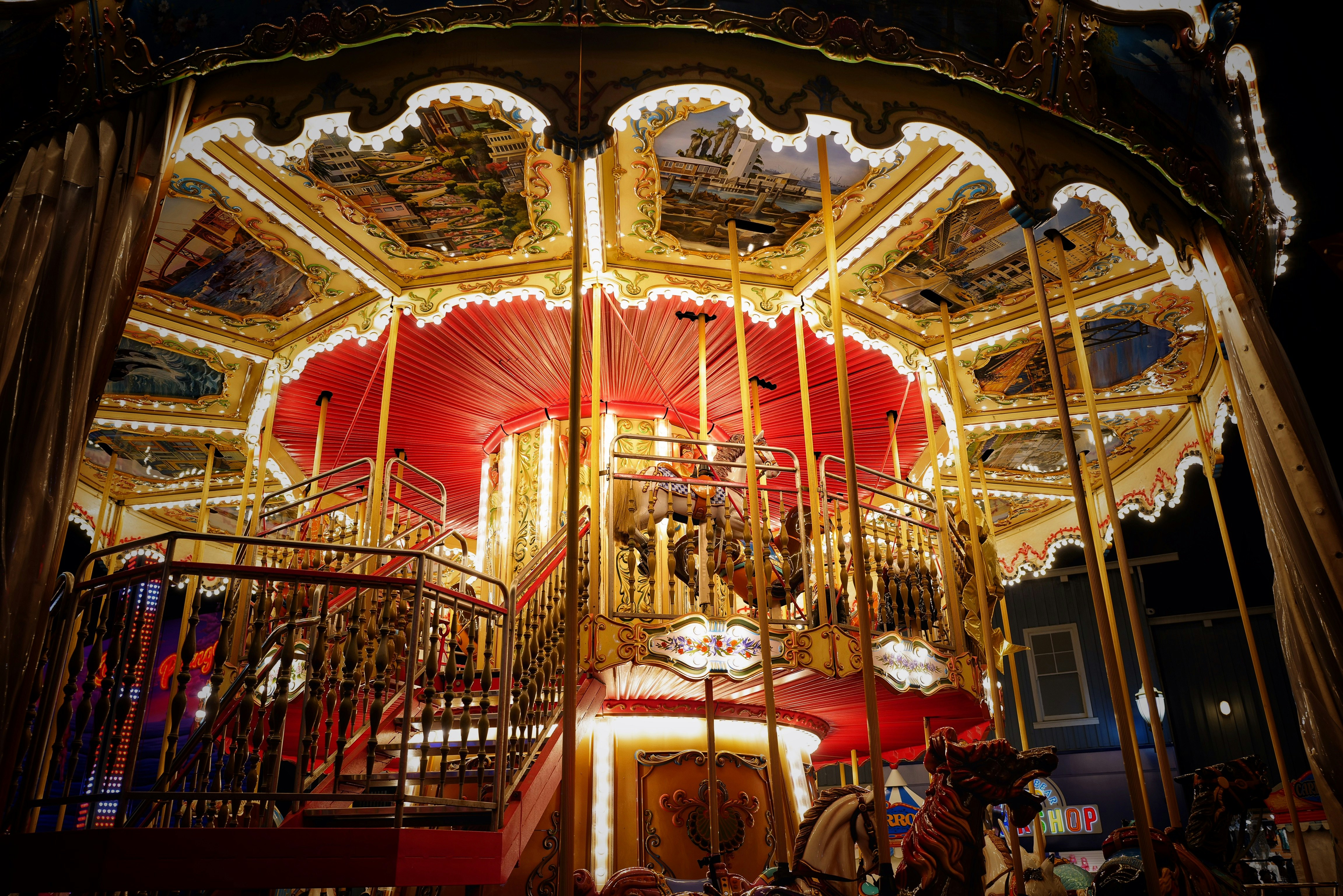 people sitting on red chairs in front of carousel