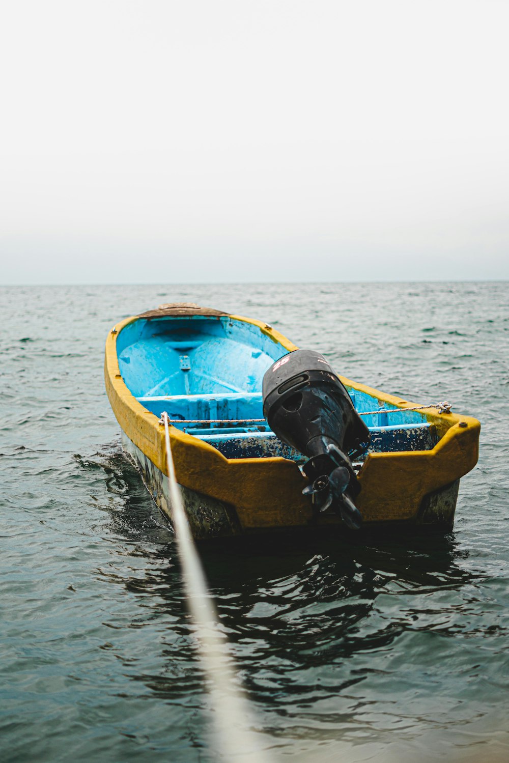 blue and yellow boat on water during daytime