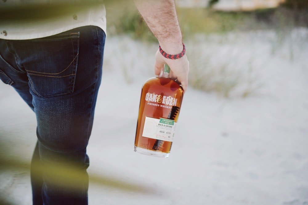 person holding orange plastic bottle