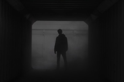 silhouette of man standing in front of window