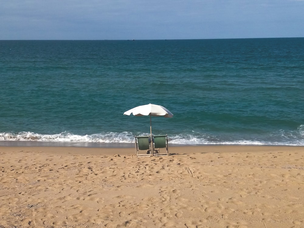 white parasol on beach shore during daytime