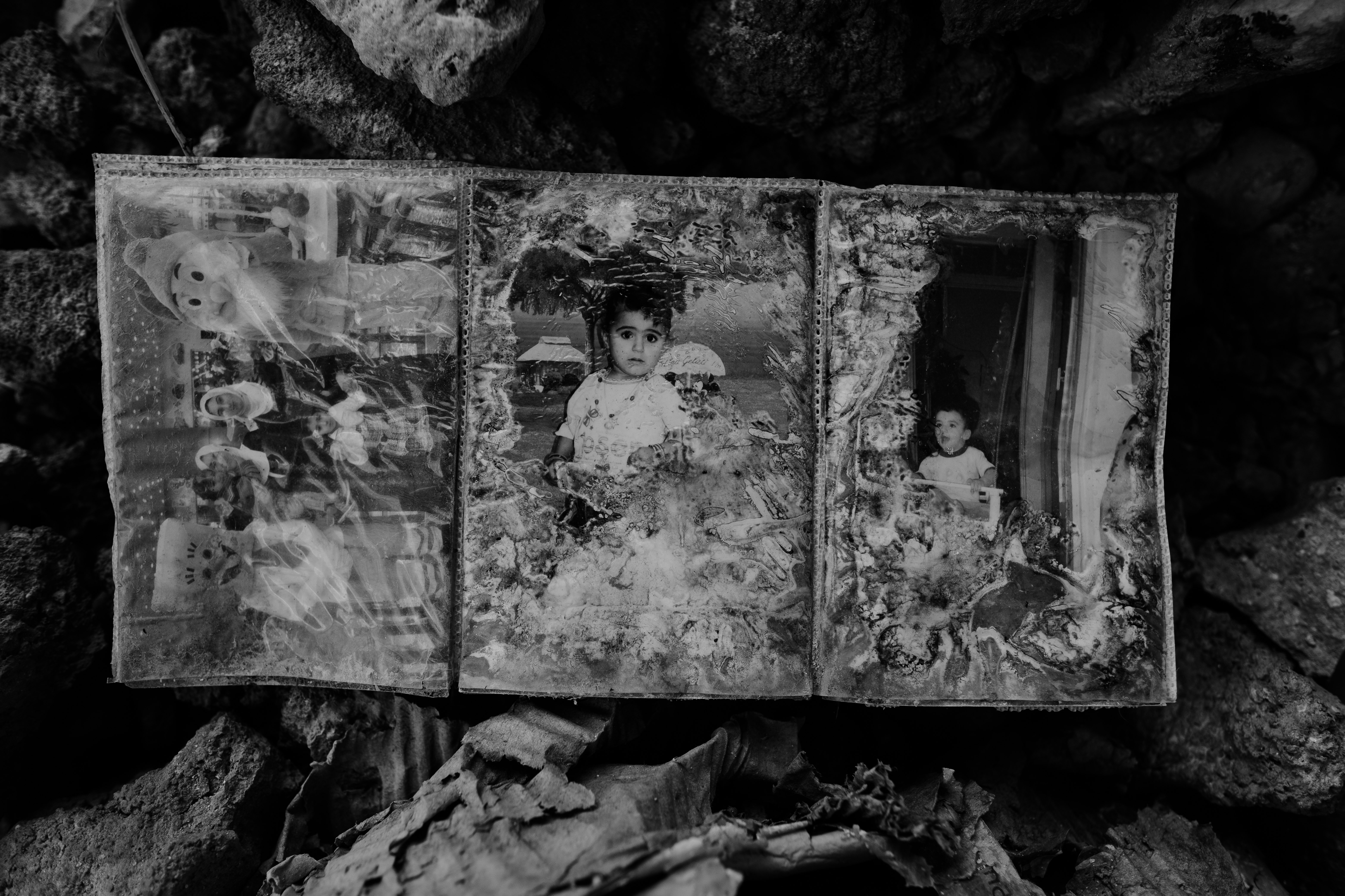 grayscale photo of 2 children standing on rock