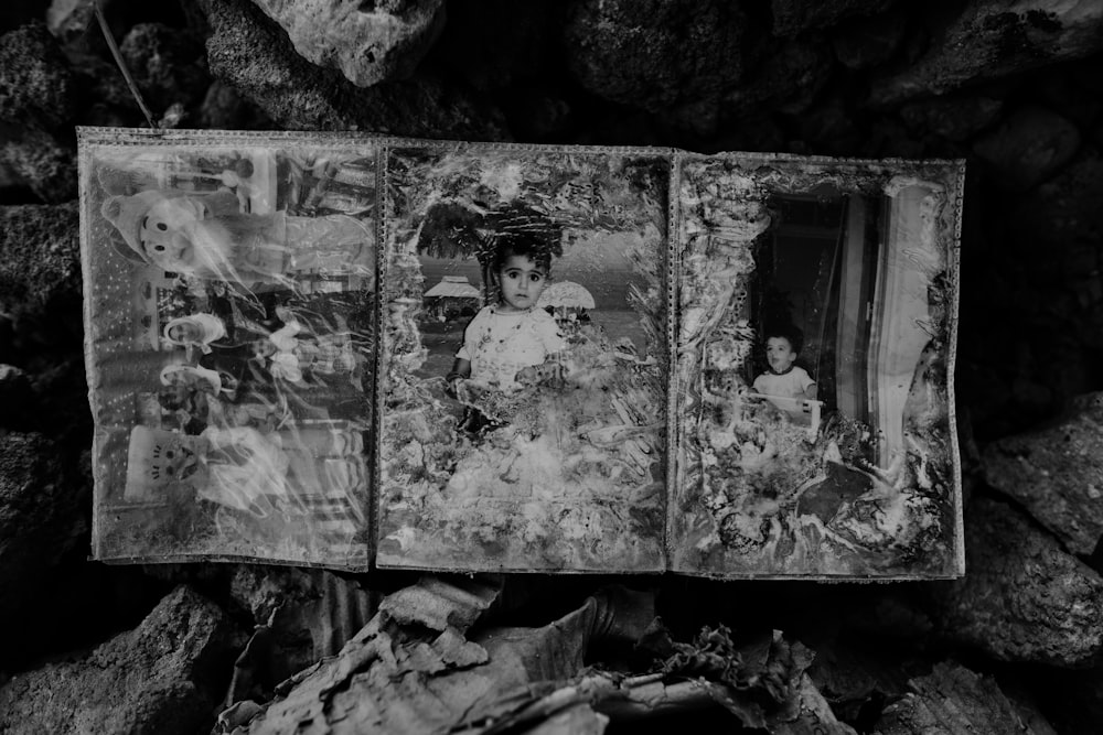 grayscale photo of 2 children standing on rock