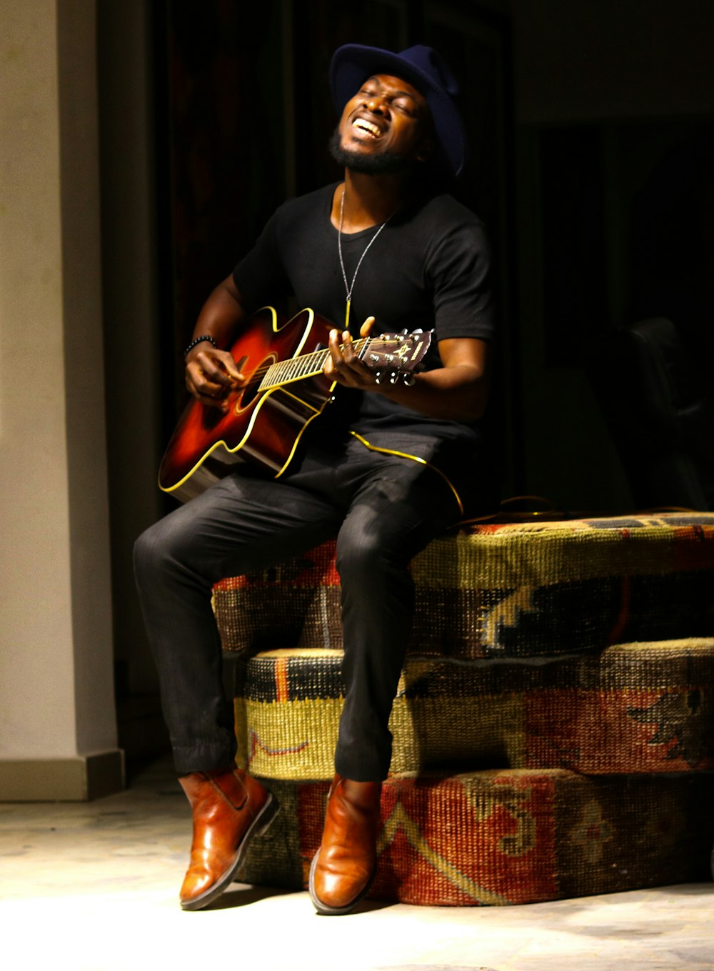 Man in black long sleeve shirt and blue denim jeans playing brown acoustic  guitar photo – Free Nigeria Image on Unsplash