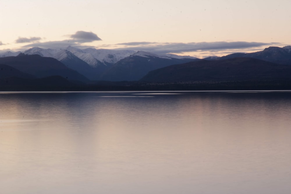 body of water near mountain during daytime