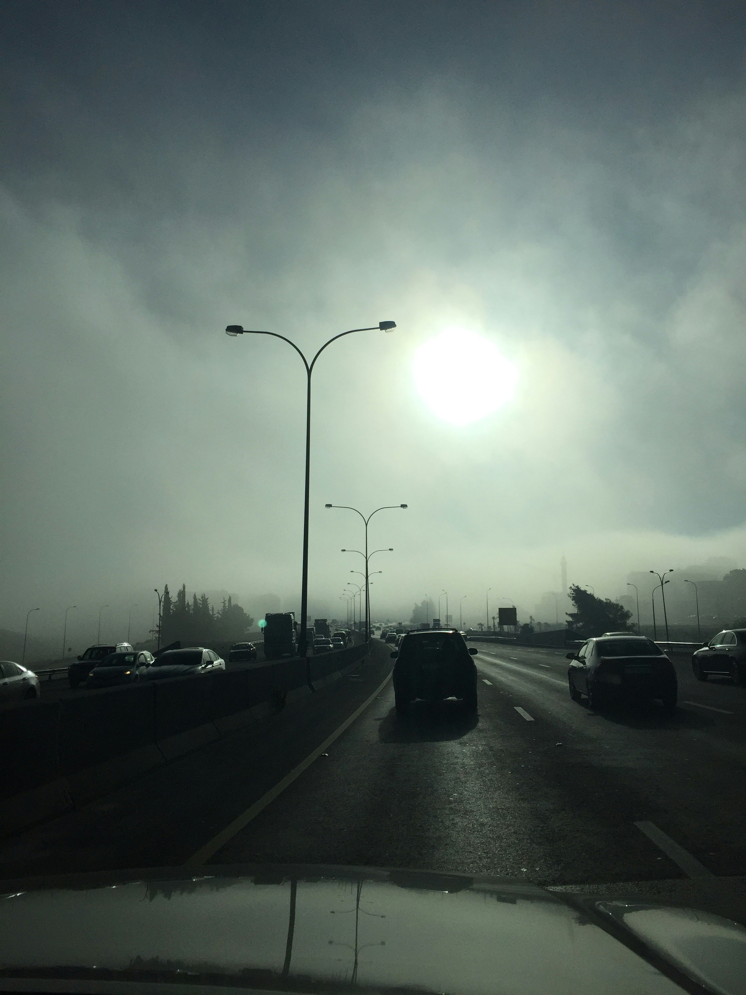 Phoenix Arizona summer heat haze over highway with cars, intense sunlight and desert landscape in background