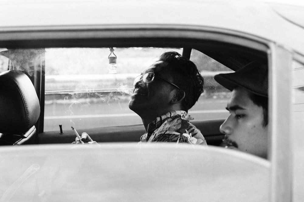 grayscale photo of man and woman in car