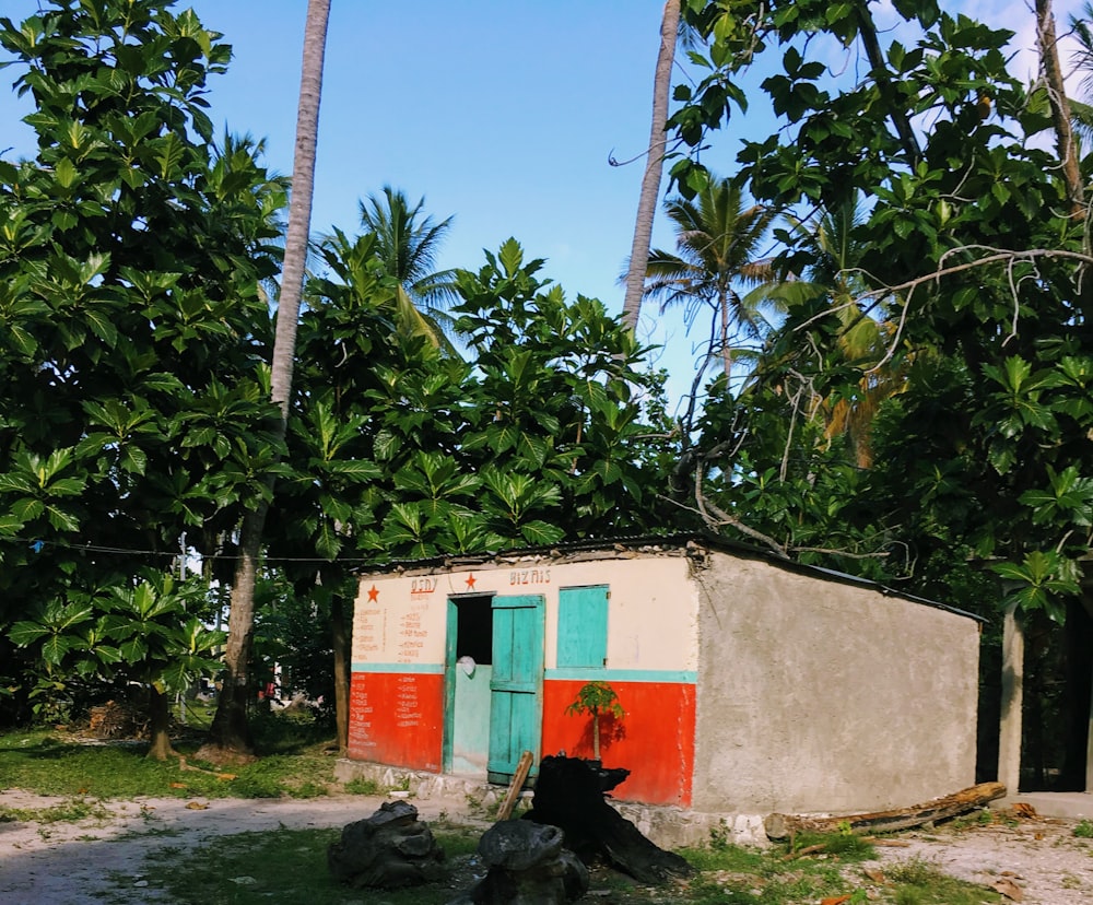 white and red concrete building near green trees during daytime