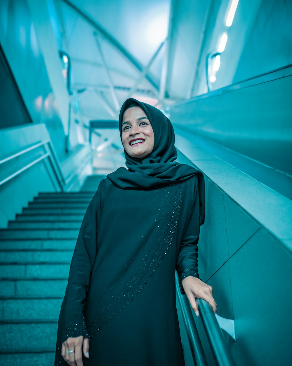 uma mulher em um hijab em pé em um conjunto de escadas